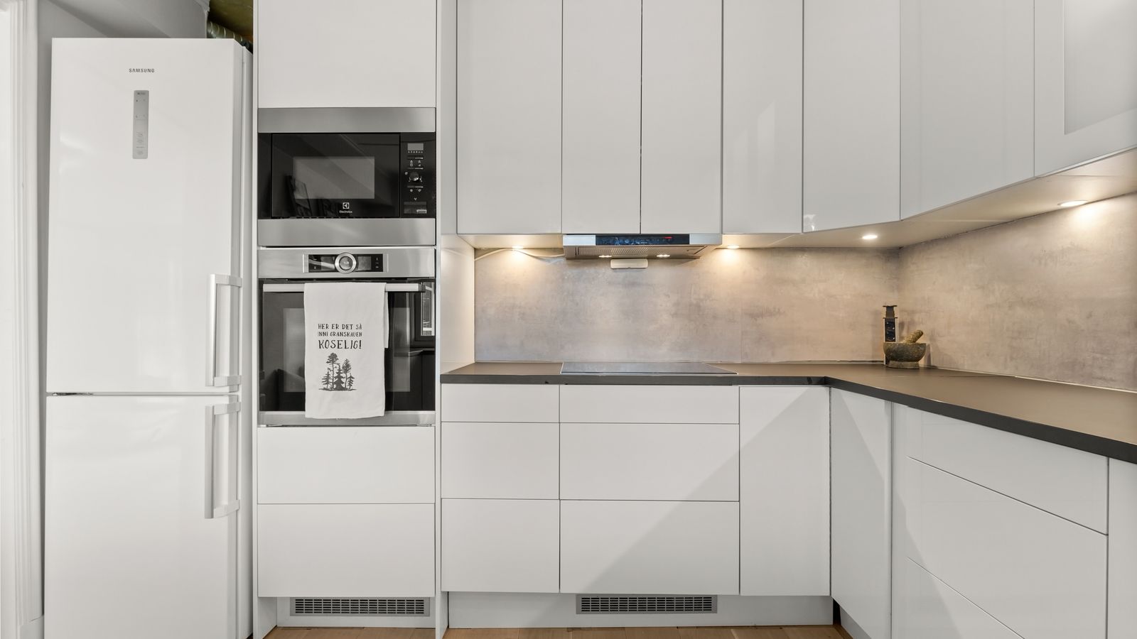Sleek modern kitchen featuring white cabinetry, built-in appliances, and minimalist design.