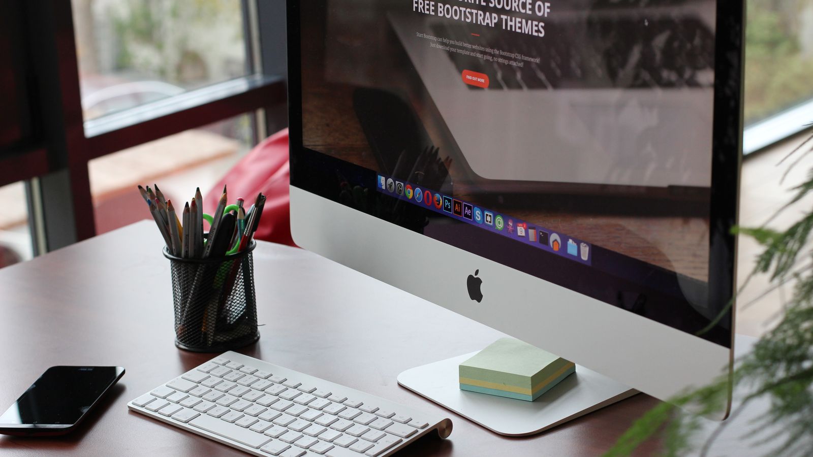 A clean, organized desk setup featuring a computer display, keyboard, and office supplies.