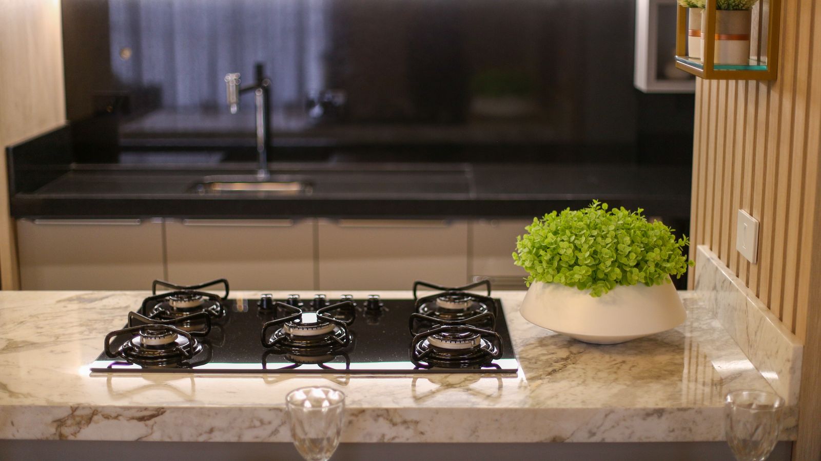 A stylish kitchen featuring a gas stove, marble top, and indoor plants. Perfect for home interior inspiration.