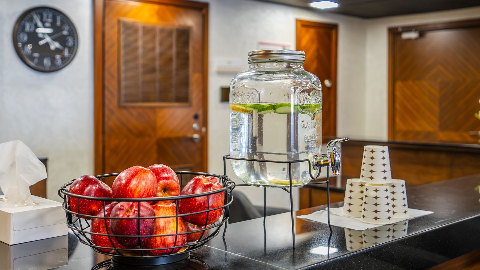 A hospitality setup with apples and lemon water at a reception area, ideal for welcoming guests.