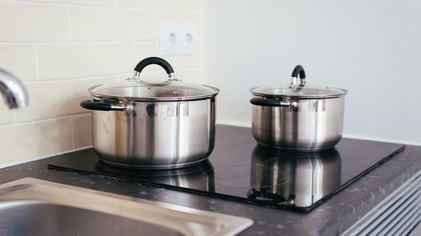 Contemporary kitchen setup with stainless steel pots on an induction stove.