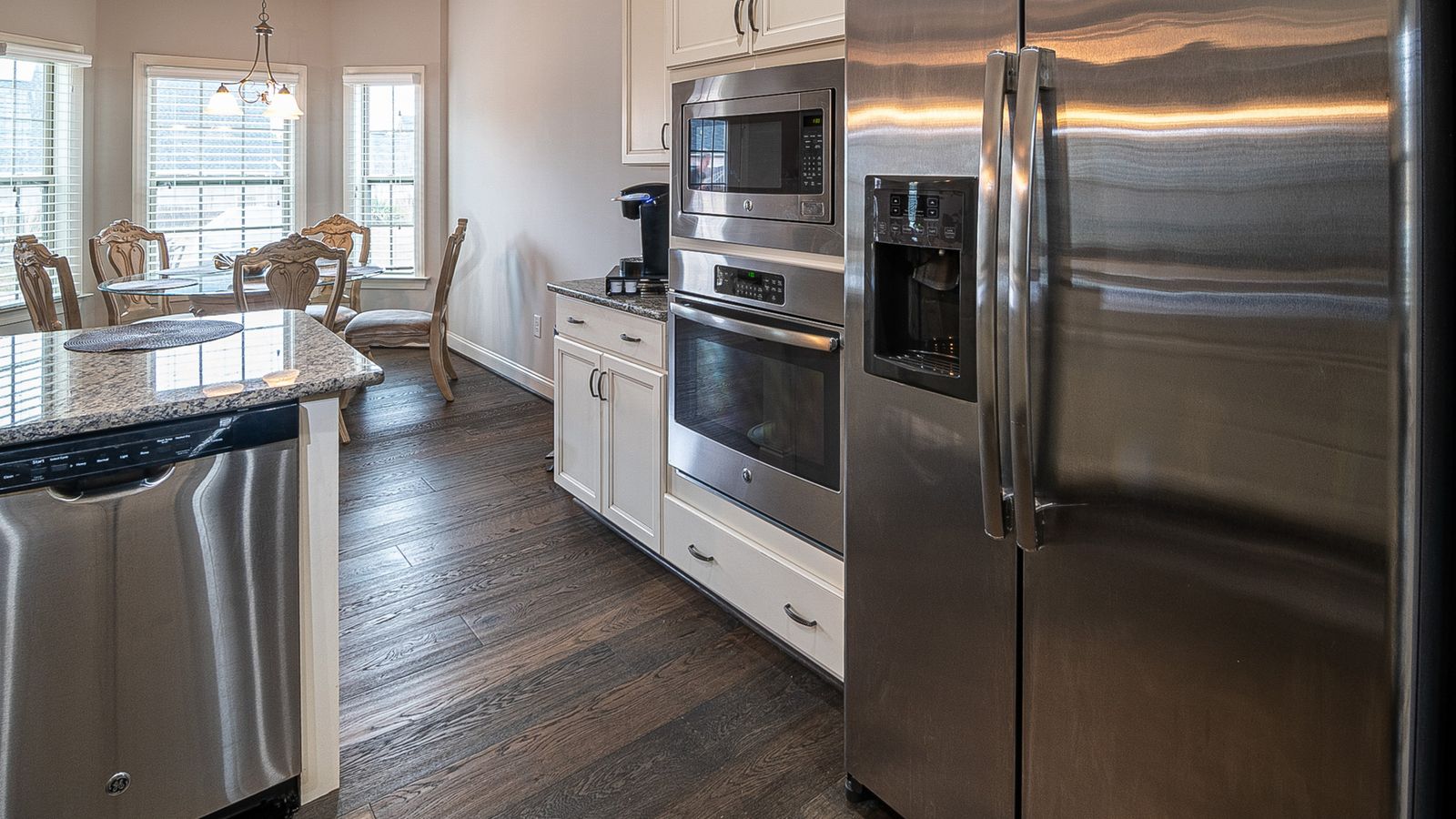 Spacious modern kitchen featuring stainless steel appliances and a dining area.