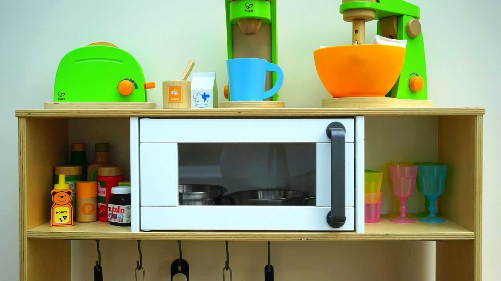 Vibrant children's toy kitchen set featuring wooden appliances and utensils, perfect for imaginative play.