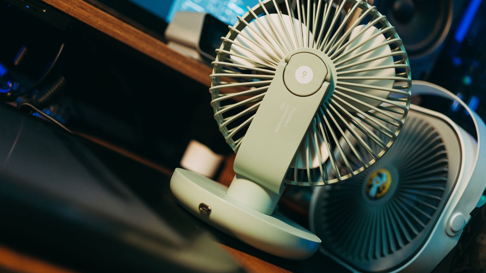 Photo of a desk setup featuring a modern compact fan, emphasizing technology and comfort.