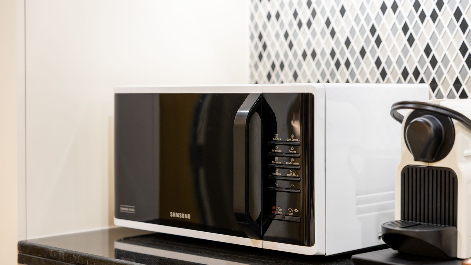 Stylish kitchen setup featuring a black microwave and coffee maker on a counter.