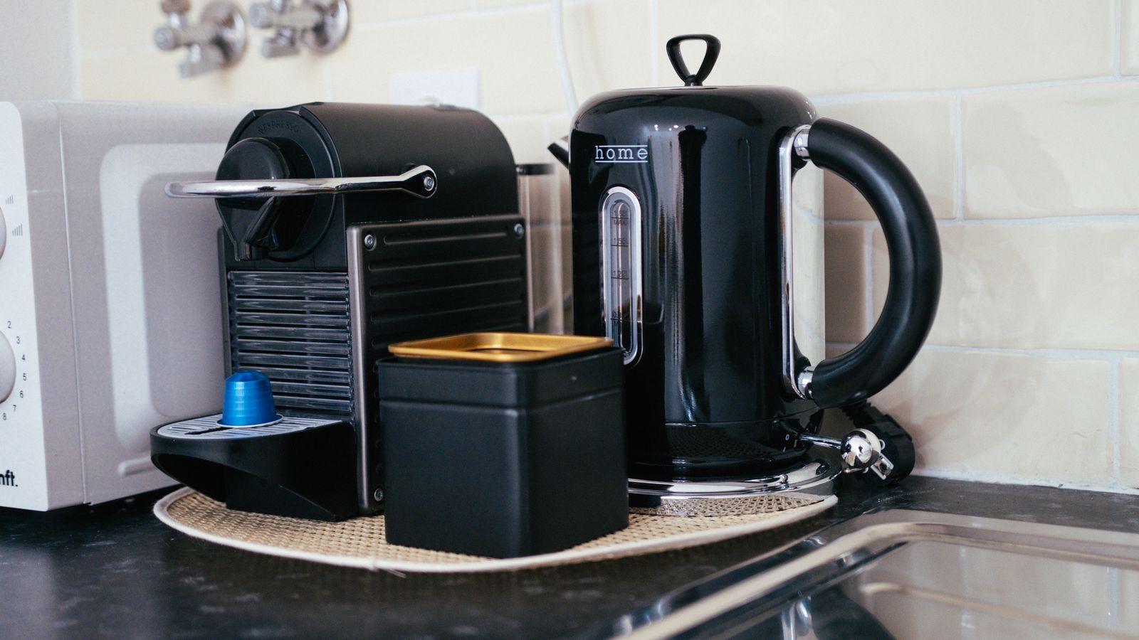 Sleek black coffee maker and kettle on a modern kitchen countertop, ideal for brewing.