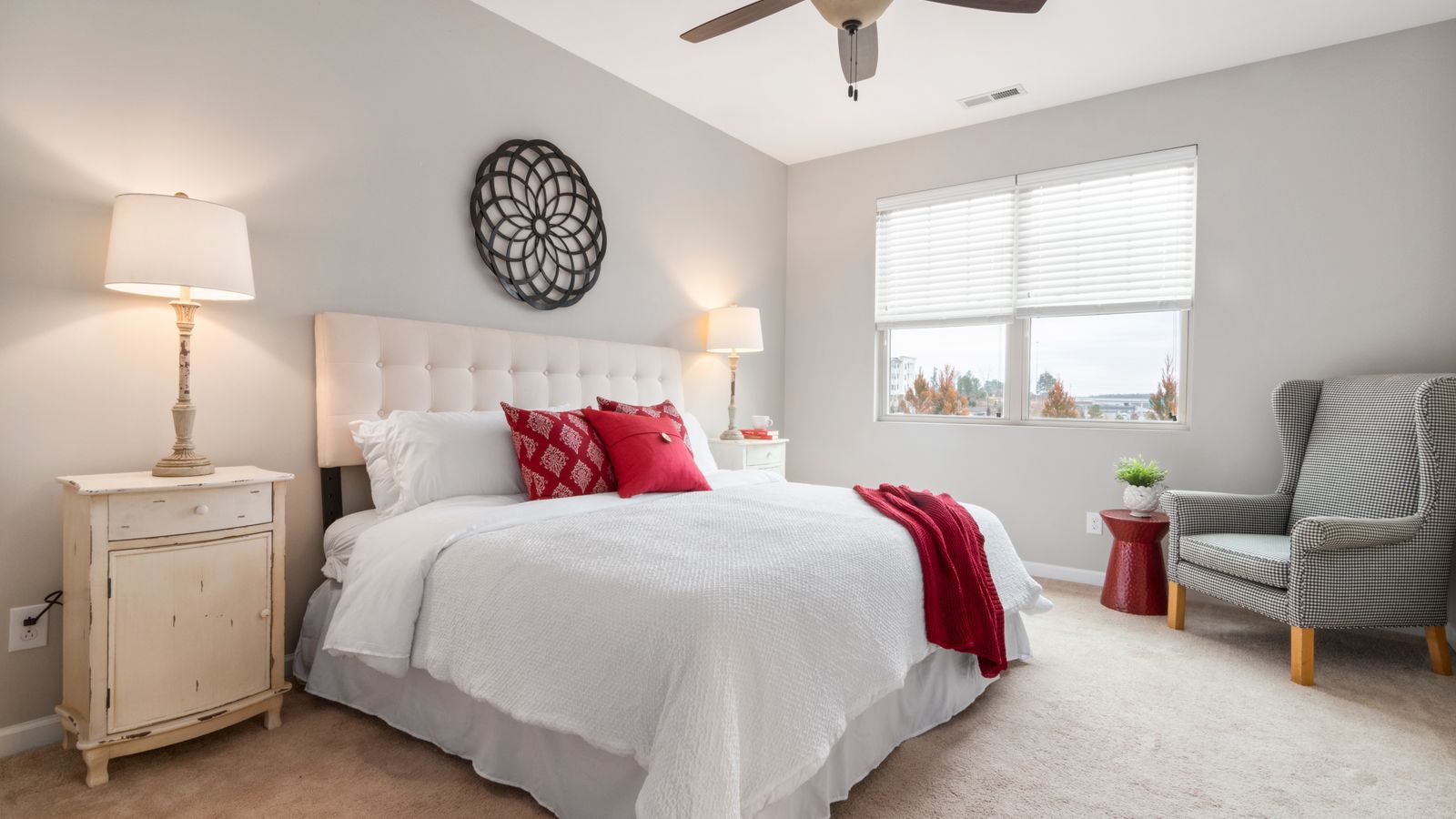 Spacious modern bedroom featuring cozy red accents and elegant decor.