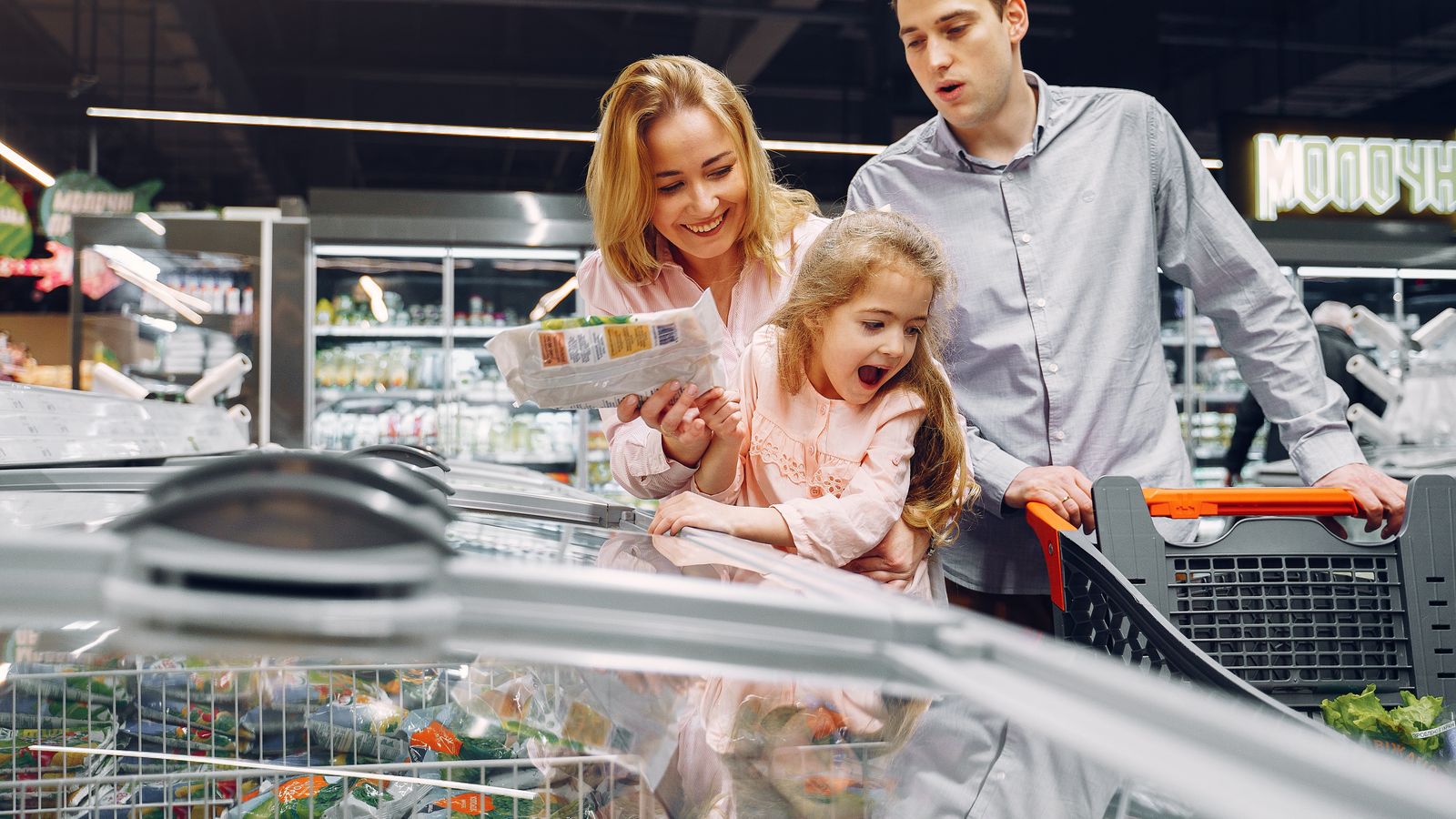 Happy family spending time together shopping at a grocery store.