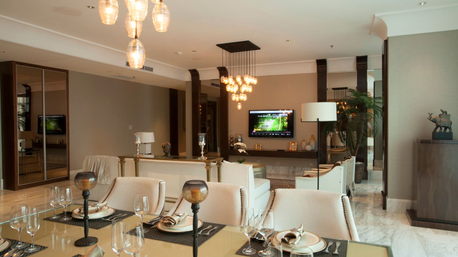 Luxurious dining and living room with modern decor and ambient lighting.