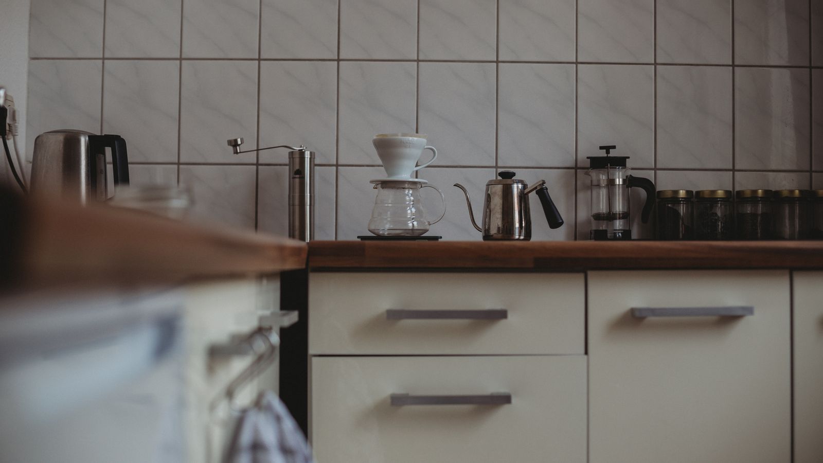 A cozy modern kitchen interior featuring various coffee-making equipment on the counter.