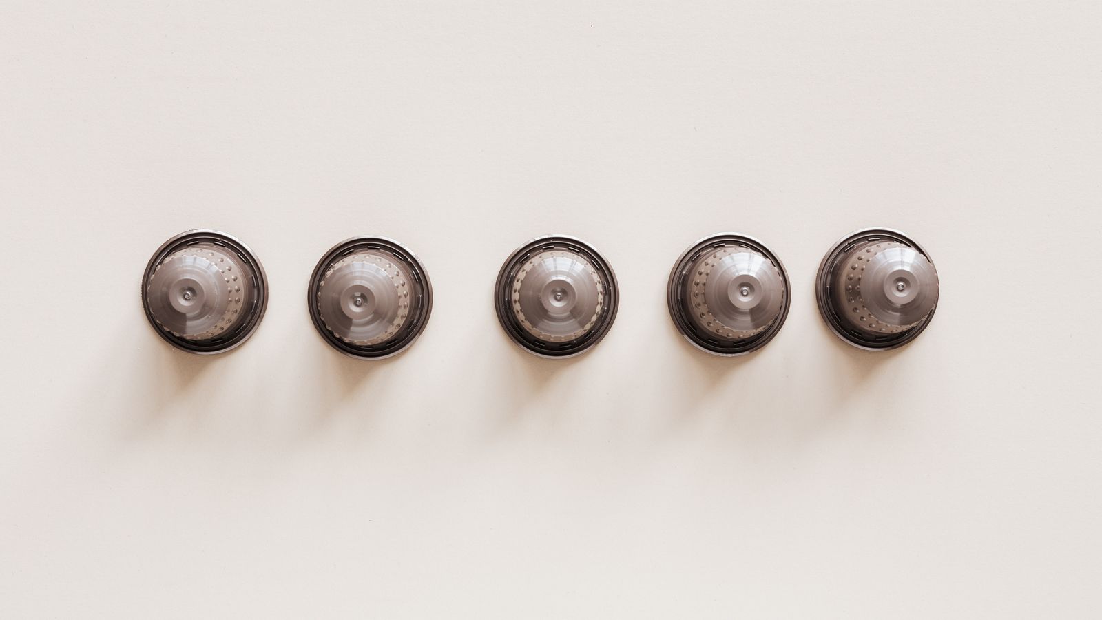 Top view of coffee blends in disposable coffee capsules for espresso machine on white background.