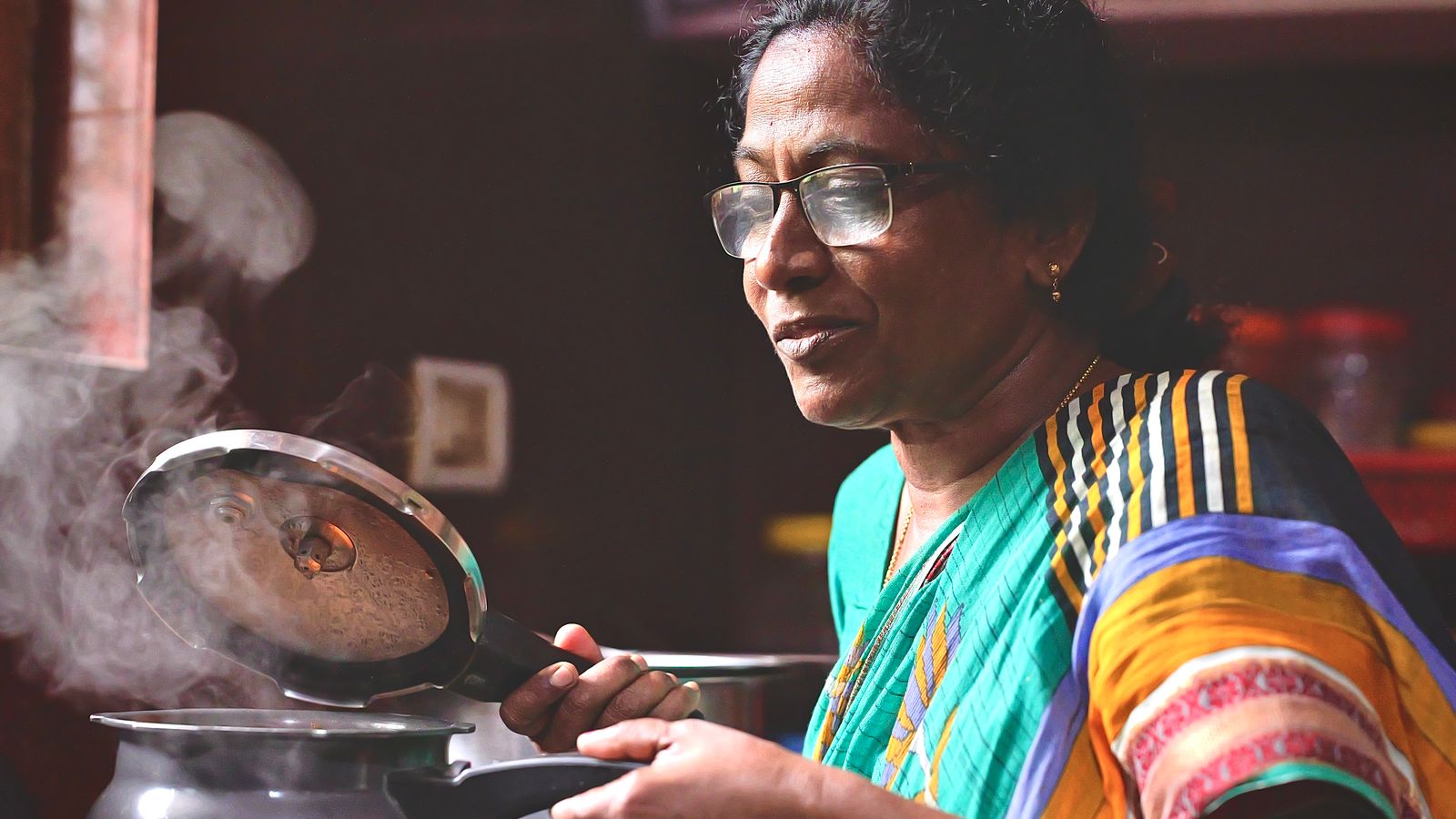 Elderly woman preparing food in a cozy kitchen, showcasing traditional cooking methods.