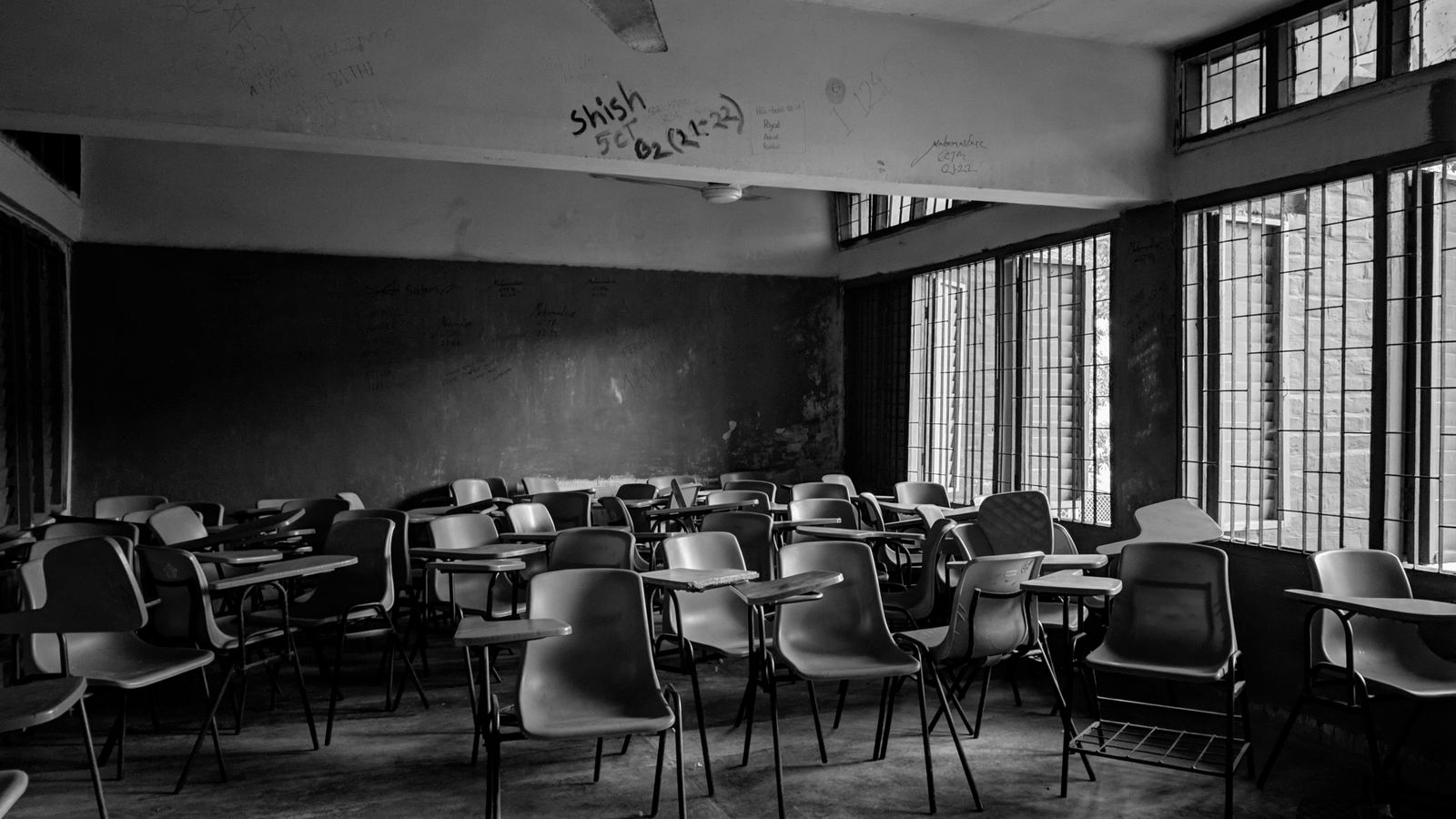 Black and white photo of an empty classroom in Bangladesh, highlighting its serene emptiness.