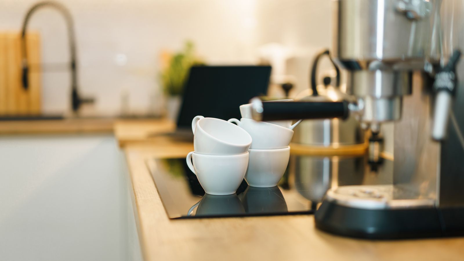 A modern espresso machine with coffee cups on a kitchen counter, showcasing a cozy and inviting setup.