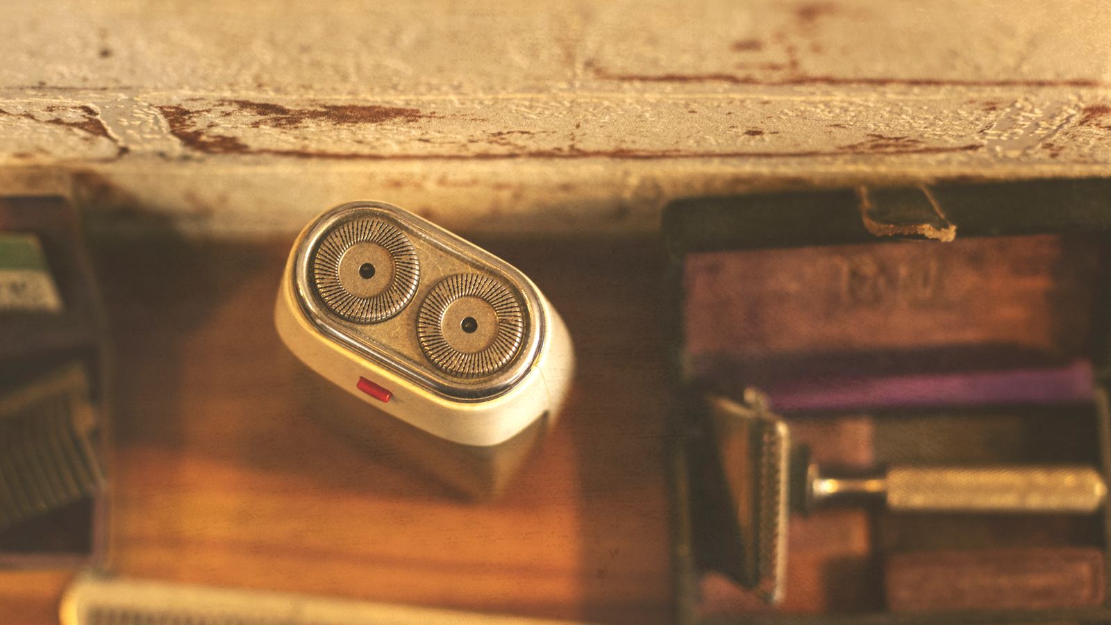 Retro electric shaver with grooming tools on rustic wooden surface.