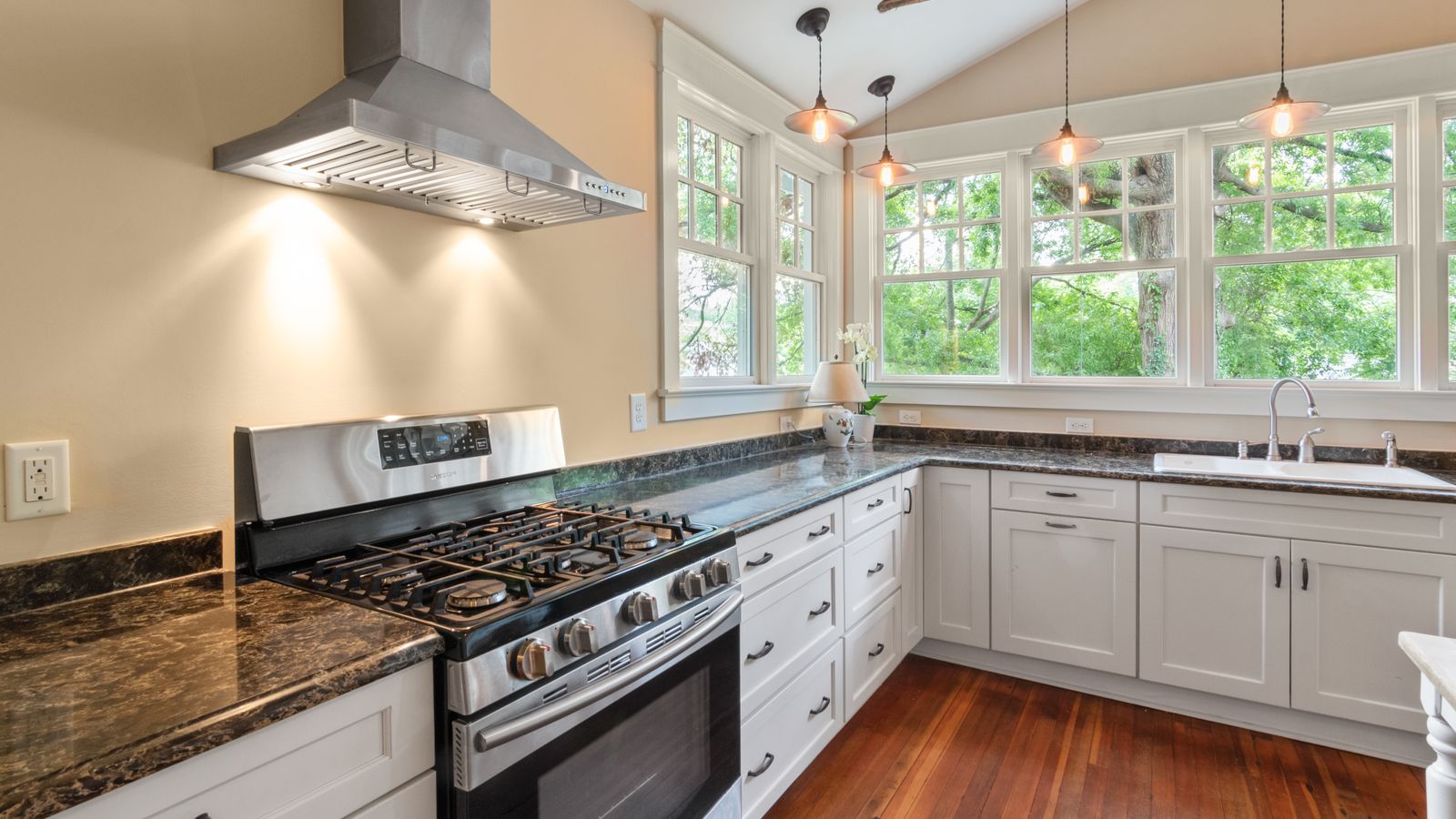 Bright modern kitchen with gas range, white cabinets, and natural light.